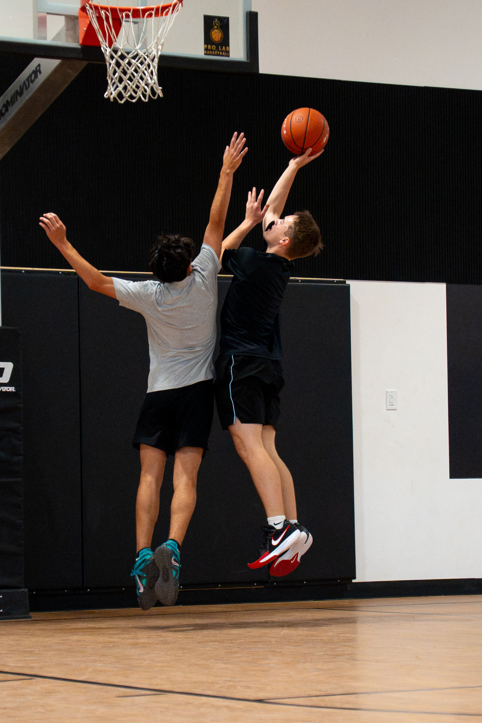 Two players contesting a layup in a Sage Hoops group session