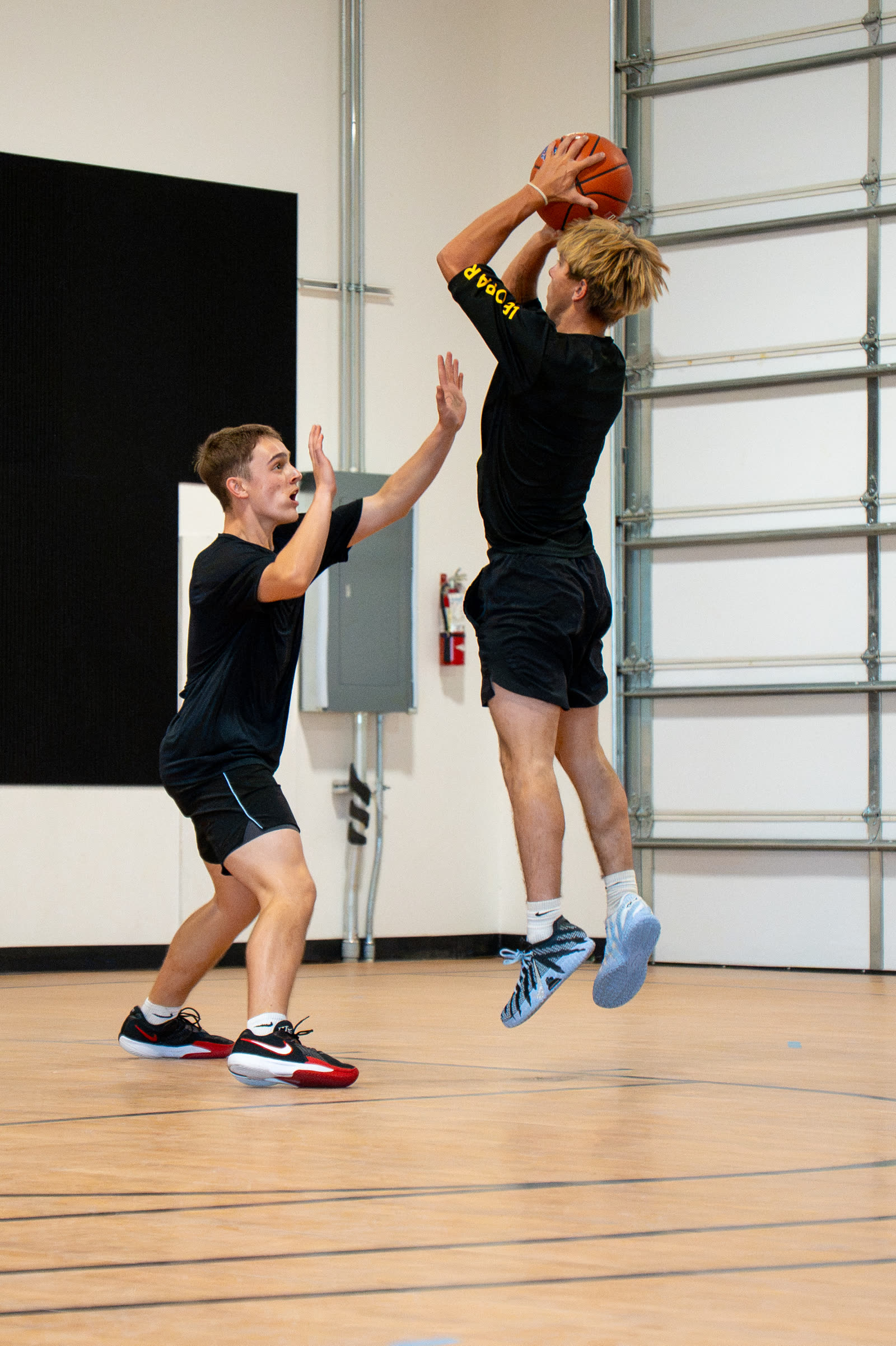 Player shooting a jump shot over a defender in group training