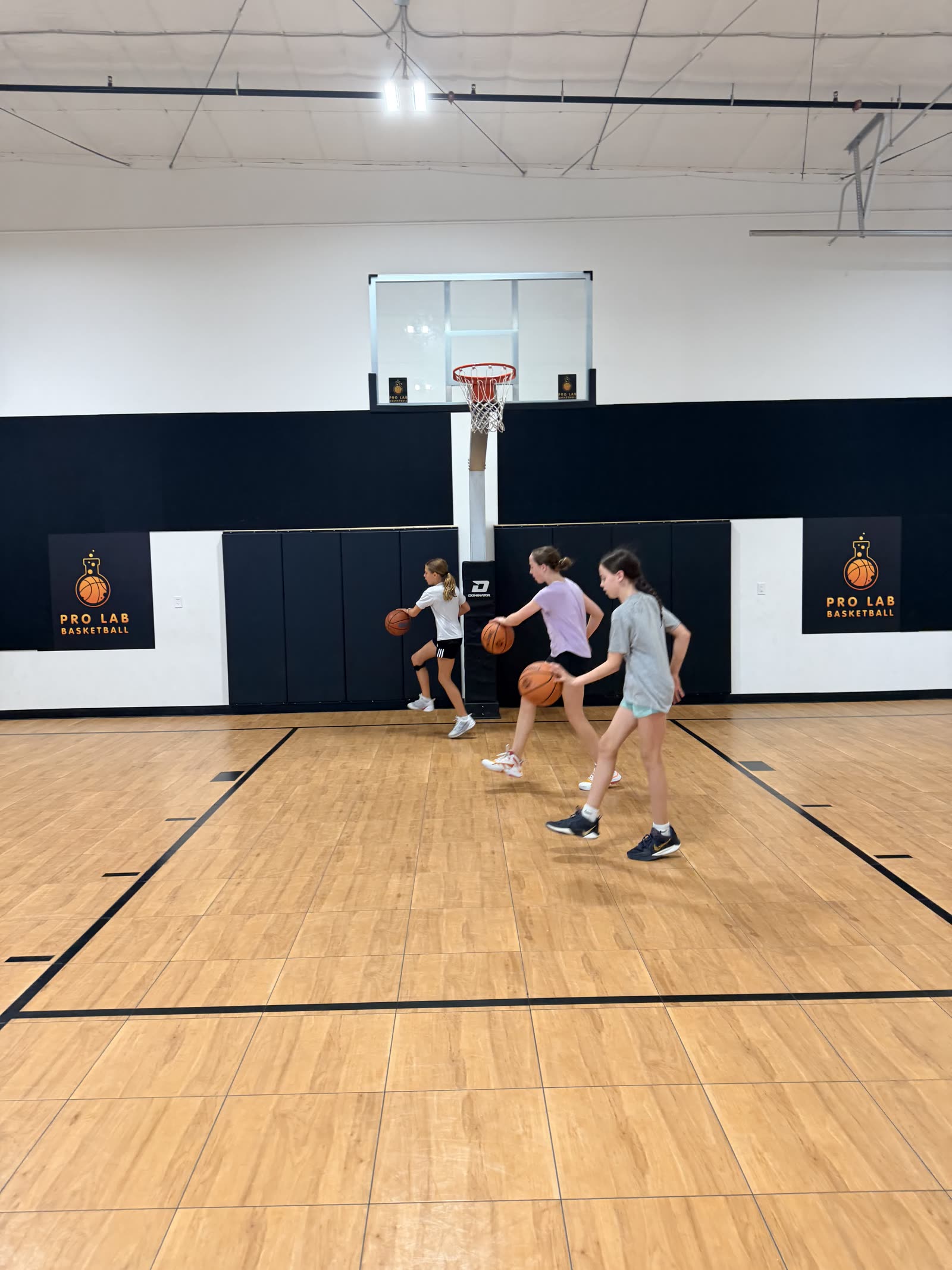Players dribbling through a group drill on the Pro Lab court